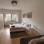 Schlafzimmer mit Bett, Nachttischen und Fenster.