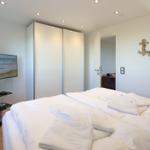 Schlafzimmer mit Bett, Kleiderschrank und Fernseher