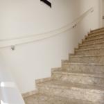 Treppe mit Marmorstufen und weißer Geländerwand.