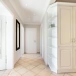 Flur mit weißen Türen, Schrank und Spiegel an der Wand.