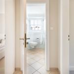 Badezimmer mit Toilette und Fenster. Zwei Schlafzimmer sind sichtbar.