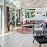 Wohnzimmer mit Sofa, Tischen und Blick auf die Terrasse.