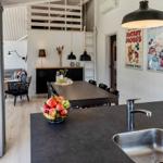 Küche mit dunklem Arbeitsplatz und Essbereich im Hintergrund