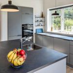 Küche mit Arbeitsplatte, Spüle und Obstschale. Durchgang zur Schlafzimmer.