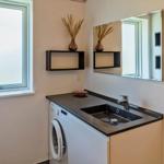 Badezimmer mit Waschmaschine, Spiegel und Fenster.