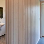 Flur mit Holzwand, Tür und Blick in die Toilette