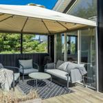 Terrasse mit Pavillon, Sitzmöbel und Blick auf Grünflächen.