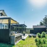 Moderne Villa mit Terrasse, Grillbereich und Garten in grüner Umgebung.