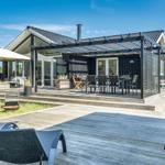 Moderne Ferienwohnung mit Terrasse, Sitzgelegenheiten und Grillplatz im Freien.