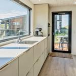 Küche mit großem Fenster und Blick auf Terrasse und Garten