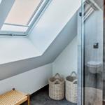 Dusche mit Glaswand, Dachfenster und zwei Körben.