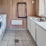 Wohnung mit Waschmaschine, Trockner und Waschbecken an Fenster.