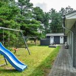Hinter dem Haus befindet sich ein Spielplatz mit Rutsche und Schaukel.
