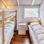 Zimmer mit Schlafcouch, Doppelbett und Fenster mit Blick auf Gras.