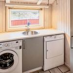 Wohnung mit Waschmaschine, Trockner und Waschbecken unter Fenster.