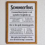 Ein gerahmtes Schild mit Text über das Sommerhaus an der Wand.