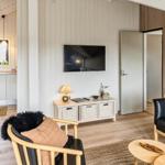 Wohnbereich mit Sofa, Sessel und Küchenbereich unter Dachschräge.