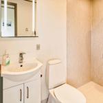 Bad mit Dusche, Waschbecken und Toilette. Spiegelschrank und Handtuchhalter sichtbar.