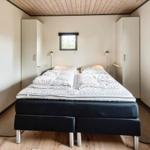 Schlafzimmer mit Bett, Kleiderschränken und Fenster. Wandbild mit Herzen.