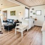 Wohn- und Küchenbereich mit Holzboden, Kamin und moderner Küche.