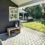 Terrasse mit Holzbank, Fenster und Blick auf den Garten.