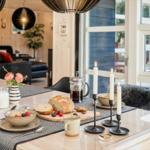 Esstisch mit Frühstück, Kerzen und Blick auf Terrasse