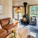 Wohnzimmer mit Sofa, Kamin und Blick auf Balkon