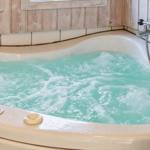 Eine Whirlpool-Badewanne mit laufendem Wasser und Holzwandverkleidung.