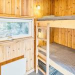 Zimmer mit Doppelstockbett und Fenster zur Waldansicht