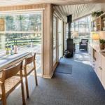Essbereich mit Tisch und Stühlen, Blick auf Terrasse und Wohnzimmer mit Kamin.