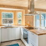 Küche mit Holzwänden, weißen Schränken und Holzoberflächen.