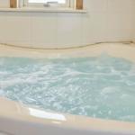 Eine Whirlpool-Badewanne mit sprudelndem Wasser und einem Hahn.