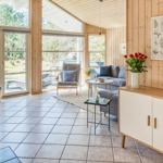 Wohnbereich mit Holzwänden, Sitzgelegenheiten und Blick auf Garten.