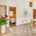 Wohnraum mit Essbereich, Schlafzimmer und Blumen auf Tisch.