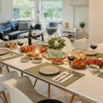 Esszimmer mit gedecktem Tisch und Sitzgelegenheiten im Hintergrund.
