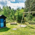 Hinterhof mit Spielplatz, Sandkasten und kleinem Holzhaus mit blauer Tür.