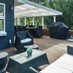 Terrasse mit Sitzgruppe, Grill und Blick in den Wald.