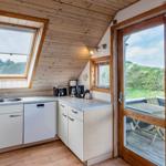 Küche mit Spüle, Waschmaschine und Fenster zum Balkon