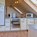 Küche mit Kühlschrank, Herd und Dunstabzug.