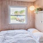 Schlafzimmer mit Holzwand, Fenster und Bett. Draußen steht ein gelber Van.