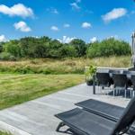 Terrasse mit Liegestühlen und Tisch unter blauem Himmel