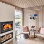 Raum mit Kamin, zwei Stühlen und Blick auf Balkon.