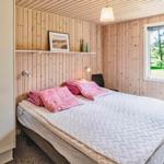 Schlafzimmer mit Bett, Kleiderschrank und Fenster zum Garten