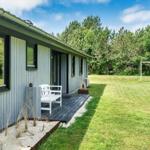 Moderne Hütte mit Terrasse, Garten und Fußballtor im Hintergrund.