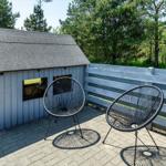 Terrasse mit zwei Stühlen neben einem kleinen Haus im Wald.