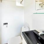 Badezimmer mit Toilette, Waschbecken und Spiegel