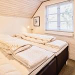 Schlafzimmer mit zwei Matratzen, weißer Wand und Fenster.