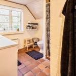 Badezimmer mit Waschbecken, Toilette und Dusche. Terrakottafußboden und Fenster mit Blick.