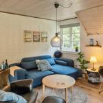 Ein Wohnzimmer mit blauem Sofa, zwei Sesseln und einem runden Tisch.