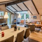 Wohn- und Essbereich mit Holzdecke, Kamin und großem Fenster